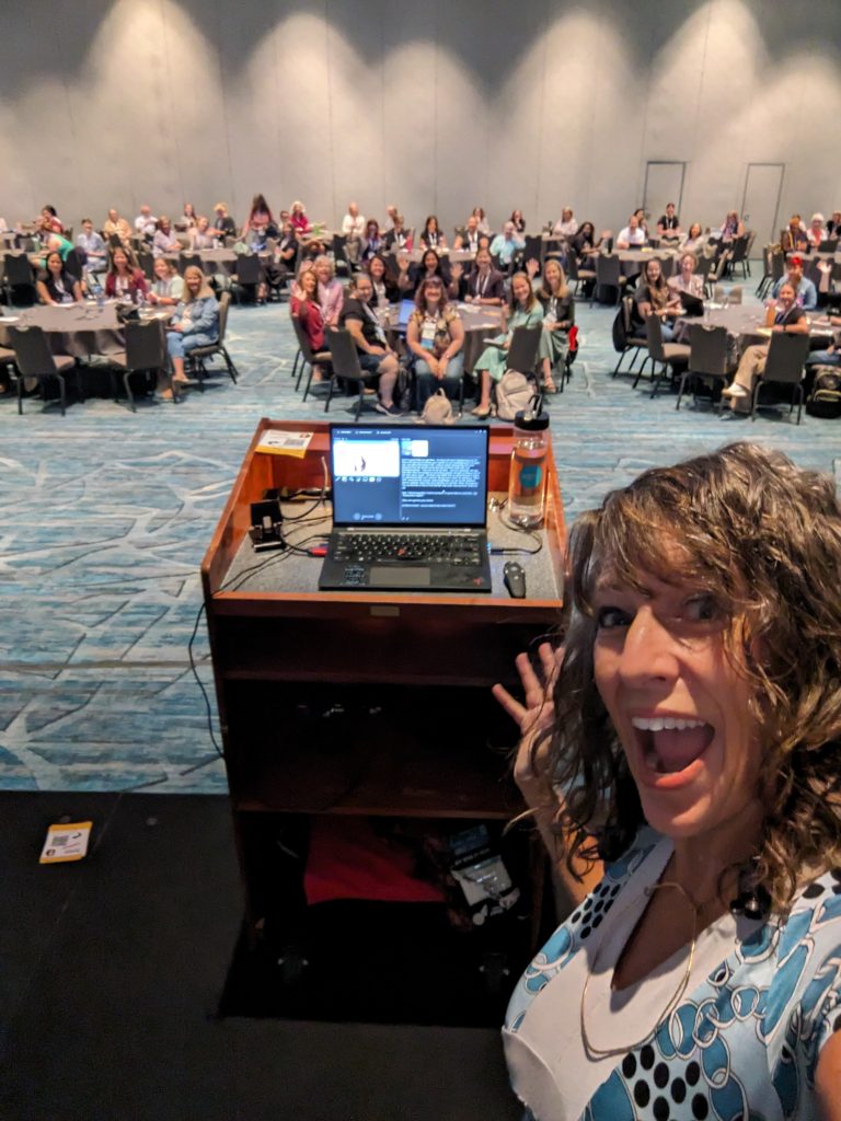 Selfie of Nancy presenting "The Tax-Ready Bookkeeper" at Scaling New Heights to a large crowd.